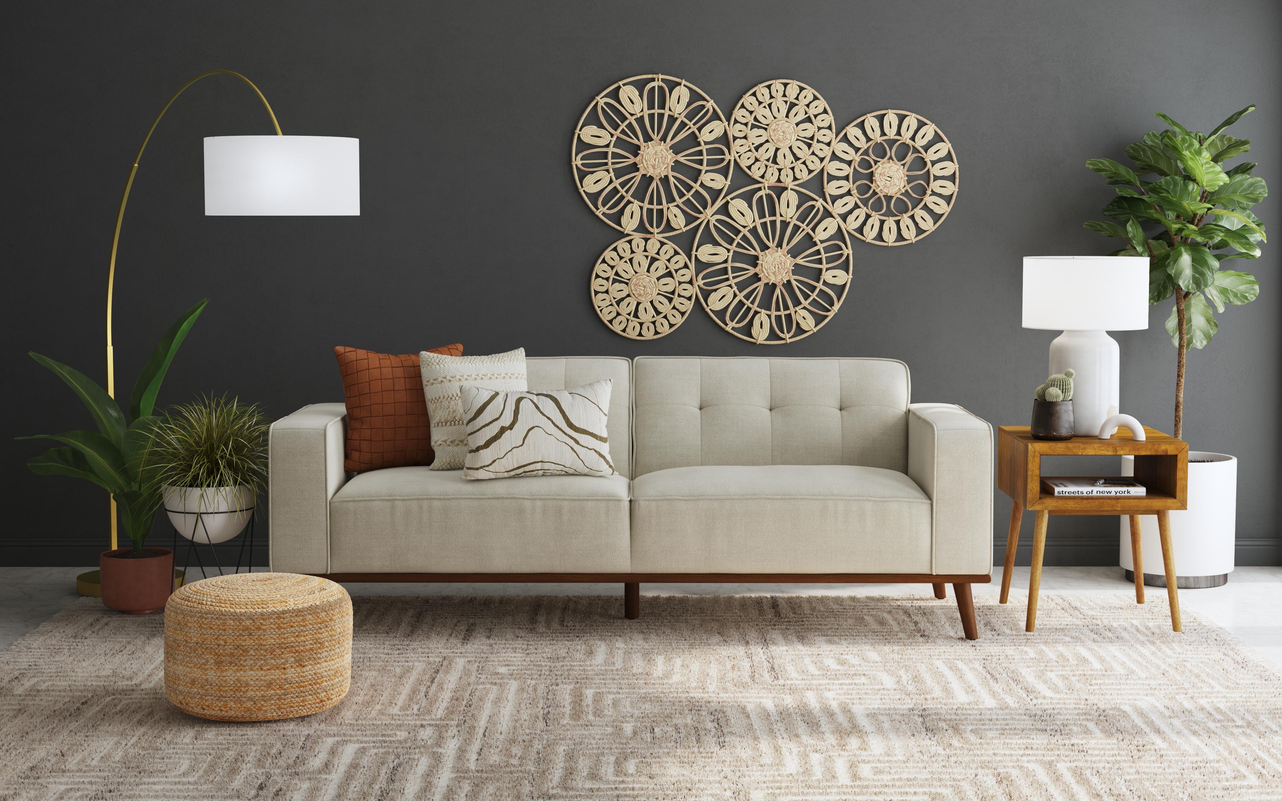 Neutral sofa styled with pillows, lamps, plants, and tables in a living room
