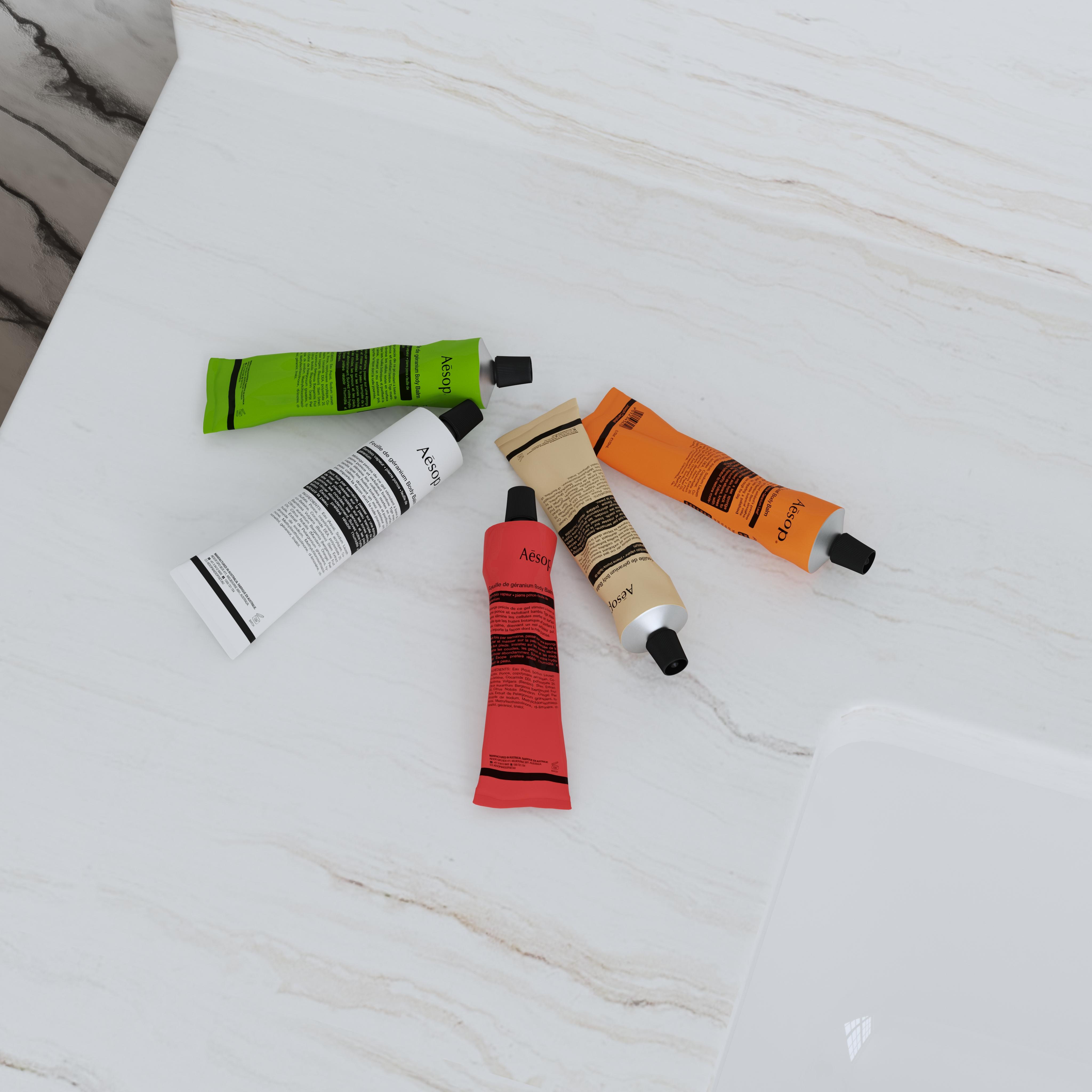 Five colorful skincare tubes arranged together on a light marble surface